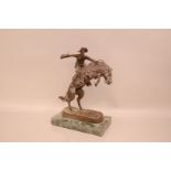 After Frederic Remington, 36cm high and marble base 24cm wide, The Bronco Buster, with bronze cowboy