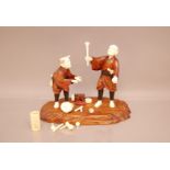 A Japanese late Meiji period carved wooden and ivory figure group of two street performers, AF,