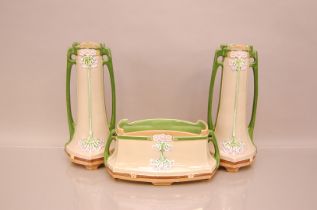 An Art Nouveau period Eichwald pottery three piece garniture, pair of vases 32cm high, with a