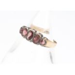 An Edward VII 9ct gold garnet five stone dress ring, rubbed over settings, on a thin shank marked