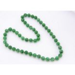 A string of jadeite jade knotted spherical beads, each approximately 12mm diameter, 35cm together,