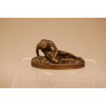 A Victorian bronze of a slave, 11cm wide oval base, with nude figure of a man resting