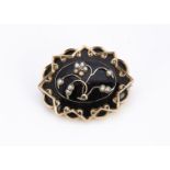 A Victorian mourning brooch, set with pearl and diamonds on a black enamel and yellow metal mount of