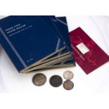 A collection of American coins, presented in several sparsely populated blue coin folders, with