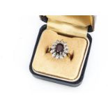 An 18ct gold garnet and diamond cluster ring, the oval mixed cut surrounded by illusion set eight
