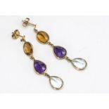 A pair of mixed gem and yellow metal drop earrings, the oval and pear cut gems in rubbed over