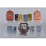 An assortment of Zippo lighters, to include a solid brass 1990 Statue of Liberty Island, a 2000