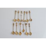 A set of twelve 19th Century continental white metal and gilt miniature spoons, the oval bowls