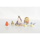 Six Royal Crown Derby porcelain bird paperweights, five with gold stoppers, together with an owl