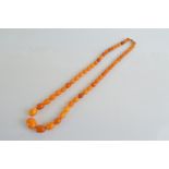 A string of graduated oval toffee coloured amber beads, largest 2.5cm, smallest 1.3cm, 39cm
