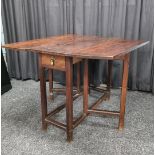 An 18th Century oak drop leaf table, having double gate leg, square legs, small end drawers to