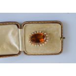 A 19th Century oval citrine and seed pearl gold brooch, in leather case, the oval gem stone in