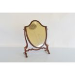 An Edwardian mahogany shield shaped dressing table mirror, with simulated ivory roundels on