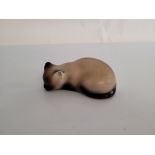 A Fornasetti porcelain Siamese cat figurine, modelled sleeping, heightened in gilt, stamped to