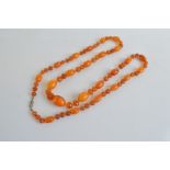 A string of mixed Baltic amber, comprising amber toffee coloured alternately set with faceted