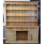 A late 19th Century pitch pine dresser, the base fitted with three frieze drawers over central dog