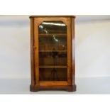 A Victorian walnut and satinwood glazed music cabinet, hinged door to three shelves, canted cornered