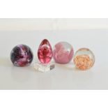 Four glass paperweights, to include Caithness Strawberry Fayre, Caithness Moulin Rouge, and two