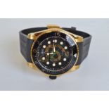A Gucci gold plated stainless steel dive watch, on rubber strap, with black face, snake