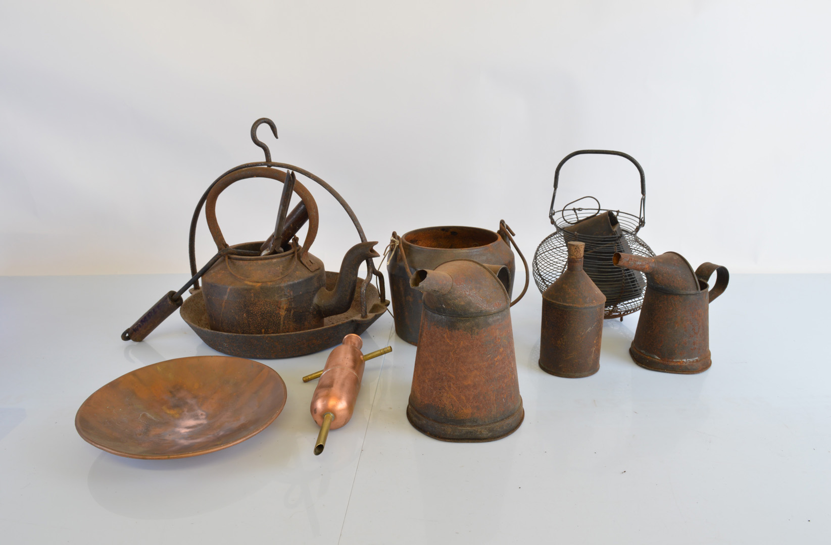 An Edwardian wirework egg basket, various glue pots, a stook wimple, various heating irons, oil jugs