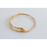 A 9ct gold serpent expandable bangle, with green gem set eyes, marked to back of serpents head