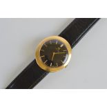 A gentleman's Omega gold dress watch, of oval shape with black face and baton numerals on black