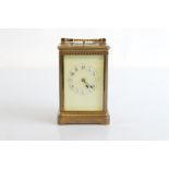 An Edwardian brass carriage clock, with repeater movement, paired case, with cream enamel dial, with