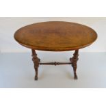 A Victorian walnut side table, of oval shape with inlaid satin wood on turned carved pilasters,