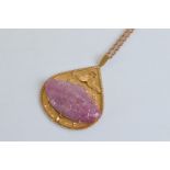 A 9ct gold and carved ruby pear shaped pendant and chain, the central carved oval cabochon ruby