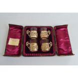 A cased Victorian silver and glass liquor set, the pierced sleeves with high scroll handles in red