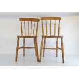 A set of six pine kitchen chairs, solid carved seats, turned supports, evidence of being chewed by a
