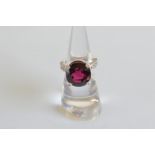 A contemporary rubellite and diamond ornate set dress ring, the circular mixed cut tourmaline with