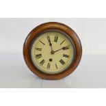 A circular mahogany wall clock, having white enamel dial with black painted Roman numerals. 28cm