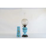 A Victorian turquoise glass oil lamp, with frosted floral decorated circular shade on glass black