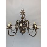 A large brass ten branch ceiling light, scroll arms above and below, on a shaped central column,