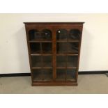 A 20th century walnut veneered and glazed bookcase, 136cm high, 106cm wide and 35cm deep