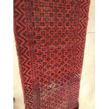 A vintage Middle Eastern woollen carpet, 340cm by 170cm, in red and blue