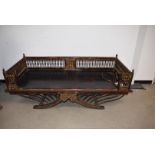 An early 20th Century Middle Eastern Opium bed, the hardwood bed, heightened in gilt and red, with