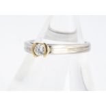 A 18ct white gold diamond set solitaire ring, brilliant cut in tension yellow gold setting, reeded