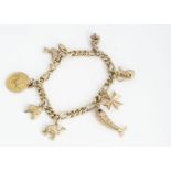 A continental yellow metal charm bracelet marked 750, the flattened curb linked bracelet, set with