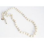 A white precious opal spherical bead necklace, knotted graduated strung beads, on a yellow metal