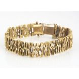 A 9ct gold textured bracelet, articulated links with tongue and box clasp, 17.5 cm long 1.2 cm