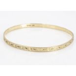 A 9ct gold bangle, of oval design, with engraved exterior, 7 cm by 6.6 cm 10g