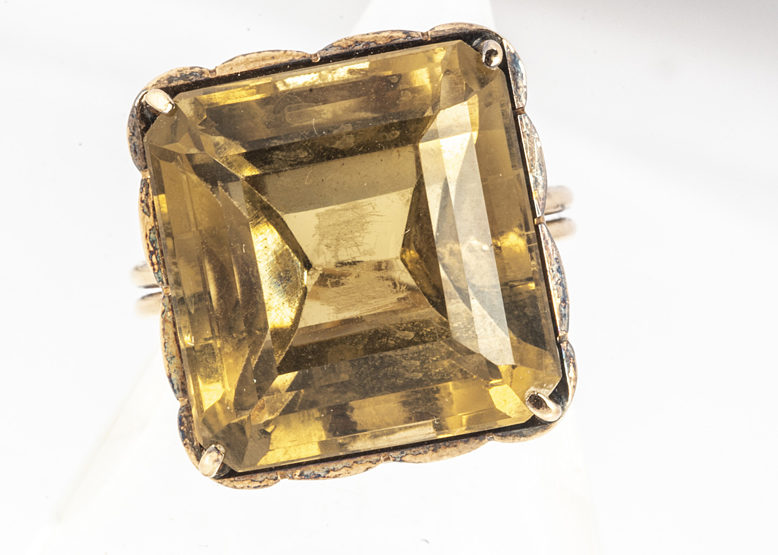 A citrine and gold dress ring, the mixed square cut, in a claw setting on a pierced basket, on a