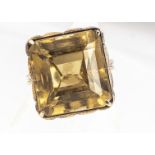 A citrine and gold dress ring, the mixed square cut, in a claw setting on a pierced basket, on a