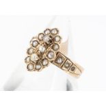 A continental yellow metal and seed pearl dress ring, oval shape with a central band of pearls and