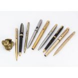 A group of seven pens, including a pair of gold plated Sheaffer fountain pens and a biro, three
