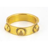 A 19th century gilt metal hinged bangle, oval shape with applied roundels, 5.5 cm by 5.2 cm