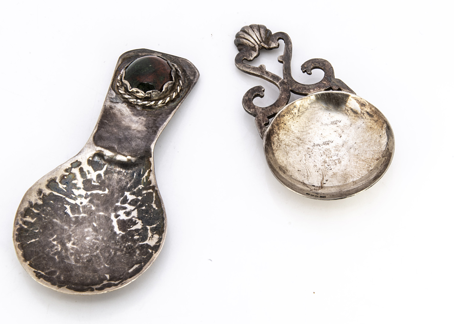 A 1980s Scottish silver tea caddy spoon from PD AC, together with a white metal hammered tea caddy