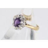 An amethyst and diamond 18ct gold cluster ring, the central oval mixed cut amethyst in claw setting,